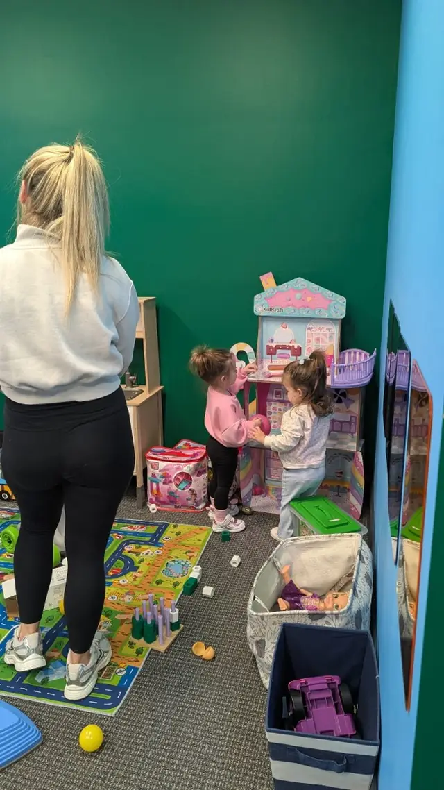 Kids playing with dollhouse while staff supervises